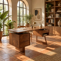 Desk with a floating top over two raised drawer cabinets in a bright home office with arched windows and plants