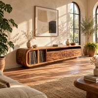 Low floating tv stand with open vinyl slots and two wide front panels in a bright living room with arched windows and plants