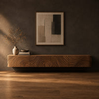 Floating tv stand with swirling tree ring carved fronts in a dark studio against a charcoal plaster wall