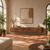 Floating tv stand with swirling tree ring carved fronts in a bright living room with arched windows and plants