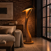Floor lamp with a bowed stem and a hooded leaf shade in an industrial loft living room with exposed brick