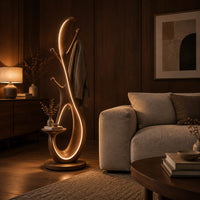 Floor lamp with an open loop body, short pegs and a small side tray in an evening living room with walnut wall paneling