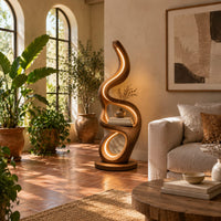 Floor lamp with serpentine loops and a small flat ledge in a bright living room with arched windows and plants