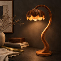 Corner detail of floor lamp with an arching stem and a petal shaped shade beside wood, brass and linen samples