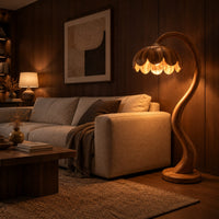 Floor lamp with an arching stem and a petal shaped shade in an evening living room with walnut wall paneling