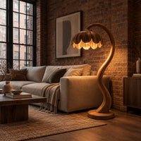 Floor lamp with an arching stem and a petal shaped shade in an industrial loft living room with exposed brick