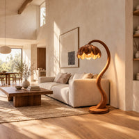 Floor lamp with an arching stem and a petal shaped shade in a bright open plan living room