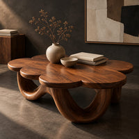 Corner detail of flower shaped coffee table on a base of looping rounded arches beside wood, brass and linen samples
