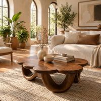Flower shaped coffee table on a base of looping rounded arches in a bright living room with arched windows and plants