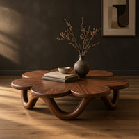 Flower shaped coffee table on a looping wave base in a dark studio against a charcoal plaster wall