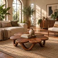 Flower shaped coffee table on a looping wave base in a bright living room with arched windows and plants