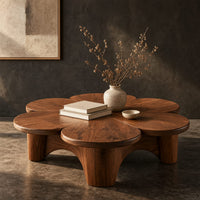 Corner detail of petal shaped coffee table on thick round legs beside wood, brass and linen samples