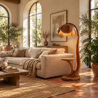 Wooden floor lamp with a flower shaped petal shade, arched stem and side tray in a bright living room with arched windows and plants