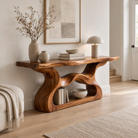 Console table with a slab top and a flowing open pedestal base in a Scandinavian entryway with white walls