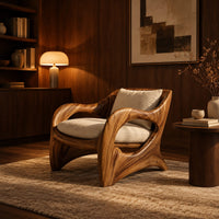 Wooden chair with sweeping open arms and cream seat and back cushions in an evening living room with walnut wall paneling