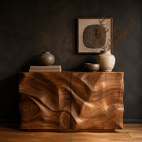Console table cabinet with two doors carved in flowing wood grain relief in a dark studio against a charcoal plaster wall