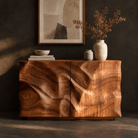 Corner detail of console table cabinet with two doors carved in flowing wood grain relief beside wood, brass and linen samples