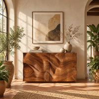 Console table cabinet with two doors carved in flowing wood grain relief in a bright entryway with arched windows and plants