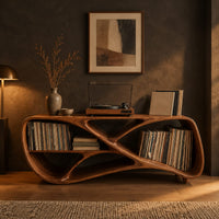 Low freeform console with a crossed ribbon frame and open bays at both ends in a dark living room at golden hour