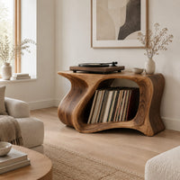 Record player stand with a flowing wave shaped body and one wide open bay in a Scandinavian living room with white walls