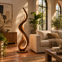 Slim floor lamp shaped as one flowing ribbon with an open loop in a bright living room with arched windows and plants