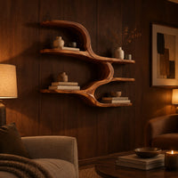 Wall shelf with four open levels joined by a flowing wave form in an evening living room with walnut wall paneling