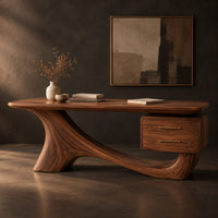 Corner detail of wooden desk with a flowing sculpted base and two drawers under one end beside wood, brass and linen samples