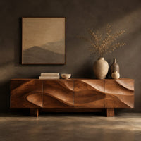 Corner detail of sideboard with four flowing swirl carved panels on two block feet beside wood, brass and linen samples