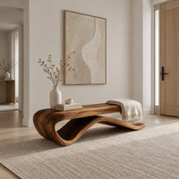 Long bench with a flat slab seat on a flowing wave base in a Scandinavian entryway with white walls