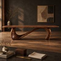 Corner detail of dining table with a long smooth top on one flowing wave shaped base beside wood, brass and linen samples