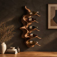 Wavy solid wood wine rack with rippling tiers shaped to cradle bottles in a dark studio against a charcoal plaster wall
