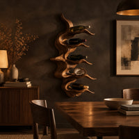 Wavy solid wood wine rack with rippling tiers shaped to cradle bottles in a dark dining room at golden hour