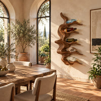 Wavy solid wood wine rack with rippling tiers shaped to cradle bottles in a bright dining room with arched windows and plants