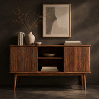 Corner detail of console cabinet with fluted side doors, an open center shelf and tapered legs beside wood, brass and linen samples