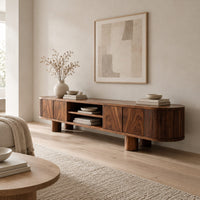 Low media stand with fluted ends, grain front panels and thick cylinder feet in a Scandinavian living room with white walls