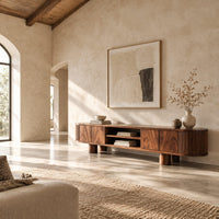 Low media stand with fluted ends, grain front panels and thick cylinder feet in a bright open plan living room