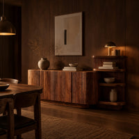 Long fluted sideboard with curved ends and an open shelf tower at one end in an evening dining room with walnut wall paneling