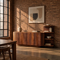 Long fluted sideboard with curved ends and an open shelf tower at one end in an industrial loft dining room with exposed brick