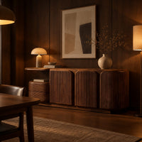 Fluted three door sideboard with curved ends and a ribbed side pod in an evening dining room with walnut wall paneling