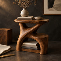 Corner detail of forked branch side table with an oval top and open lower shelf beside wood, brass and linen samples