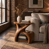 Forked branch side table with an oval top and open lower shelf in an industrial loft living room with exposed brick