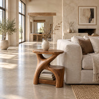 Forked branch side table with an oval top and open lower shelf in a bright open plan living room