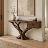 Console table on a forked tree base with two drawers at one end in a Scandinavian entryway with white walls