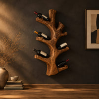 Wine rack shaped like a branching tree trunk with forked arms for bottles in a dark studio against a charcoal plaster wall