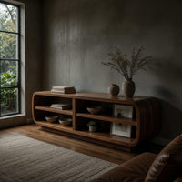 Rounded TV cabinet with four open cubbies in a concrete and timber loft