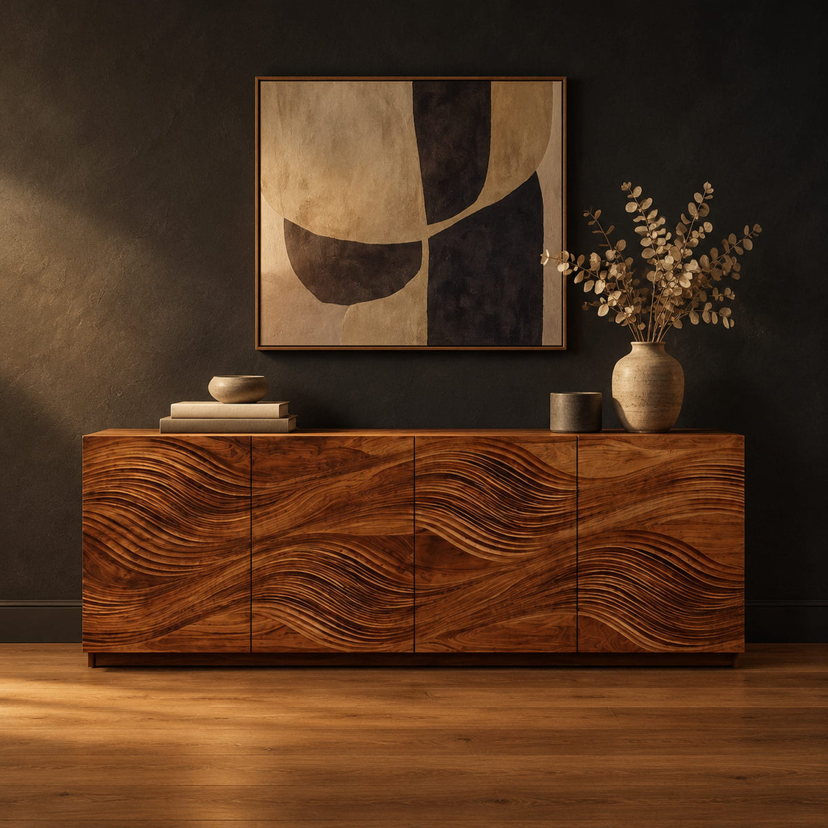 Four door sideboard with wave carved fronts on a low plinth base in a dark studio against a charcoal plaster wall