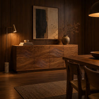 Four door sideboard with carved flowing wave lines on a plinth base in an evening dining room with walnut wall paneling
