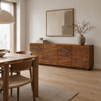 Four door sideboard with carved flowing wave lines on a plinth base in a Scandinavian dining room with white walls