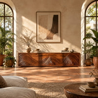Tv stand with four doors carved in swirling wave ridges in a bright living room with arched windows and plants