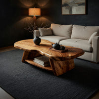 Figured wood free form coffee table with a lower shelf in a living room at golden hour